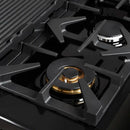 Close-up of a brass burner on the FORNO Antico 48-Inch Dual Fuel Range in black, showing precision flame ports, durable cast iron grates, and a sleek black stainless steel surface.